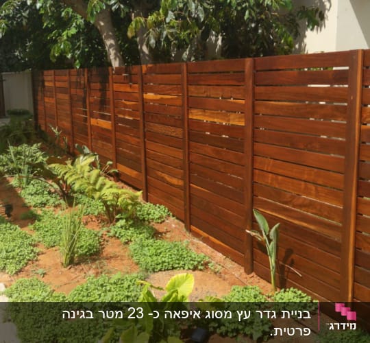 גדר עץ חומה עם צמחים ירוקים בגינה